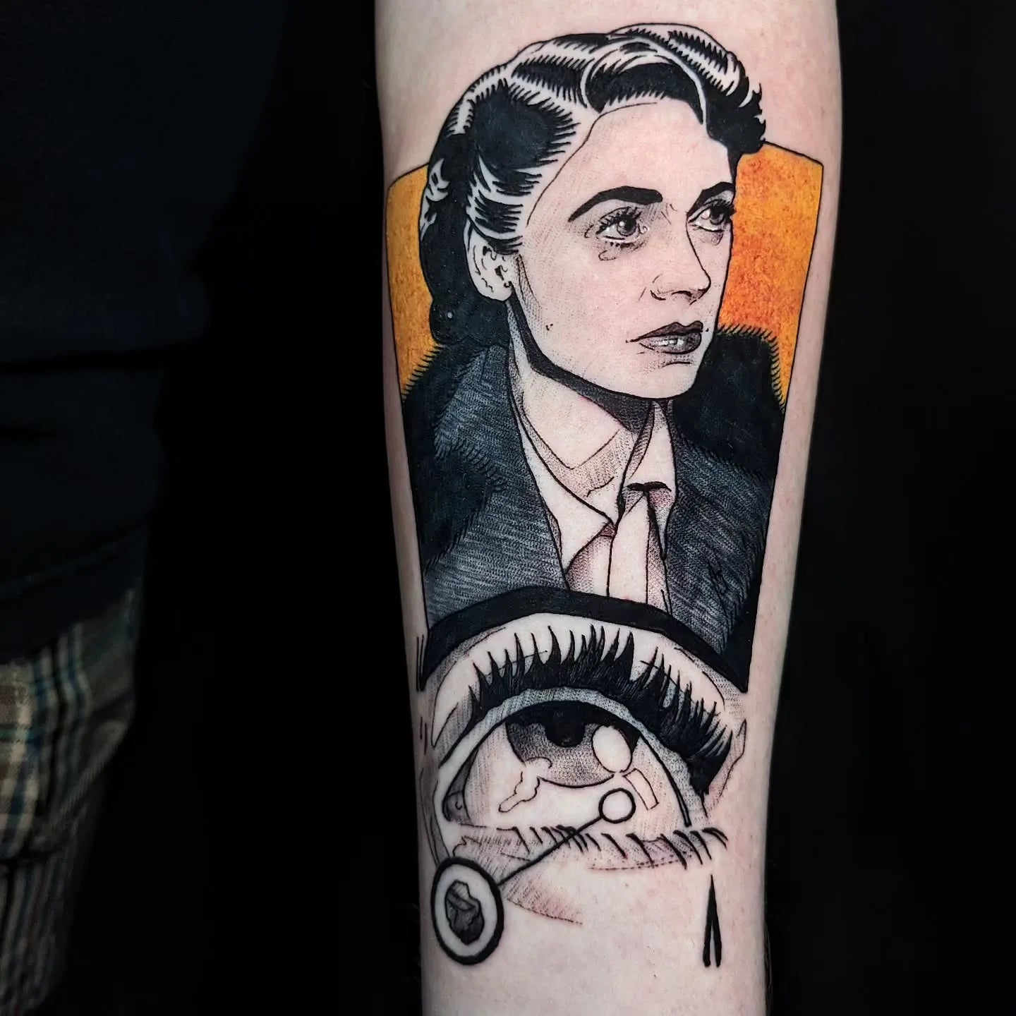 Tattoo of a woman's face and an eye in comic style