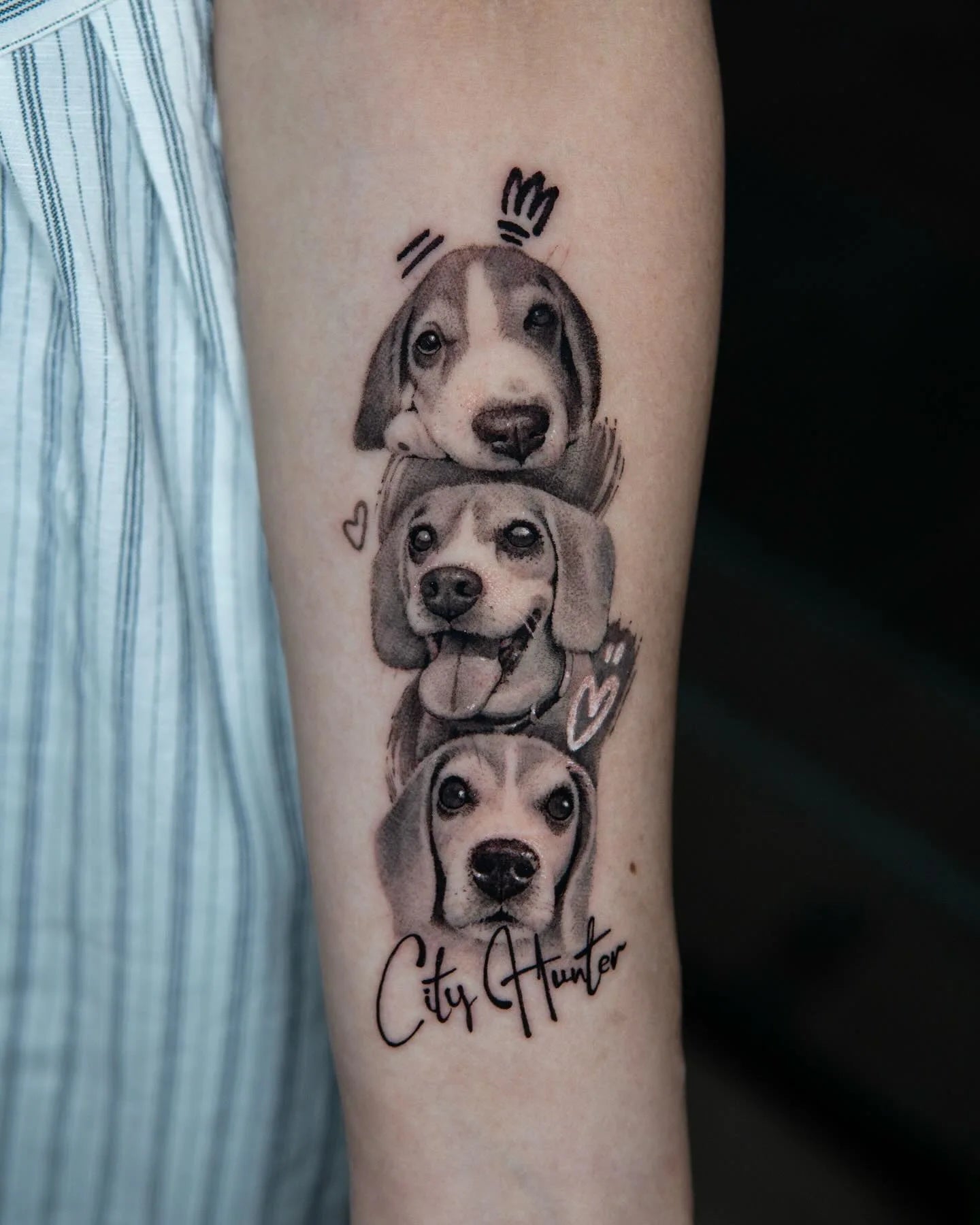 Tattoo of three dogs stacked on a person's arm with 'City Hunter' text.