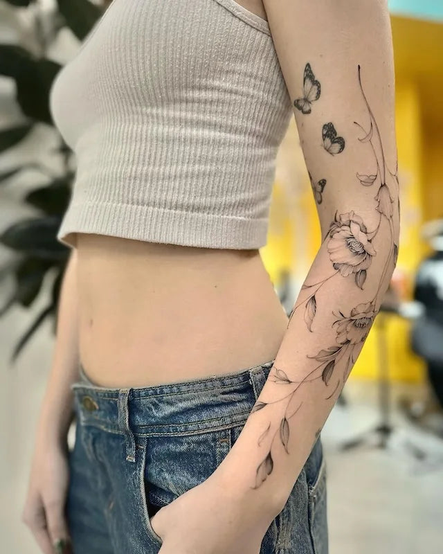 Butterflies and flowers woman arm sleeve tattoo