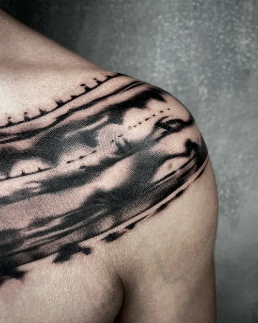 blackwork brush stroke lines tattoo on man shoulder