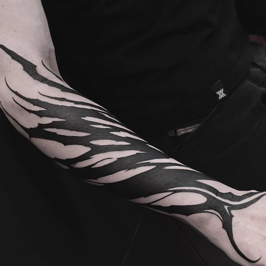 blackwork tribal pattern tattoo on forearm