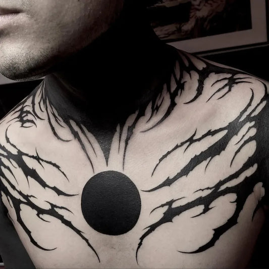 Blackwork tattoo design on a person's chest with a circular black patch