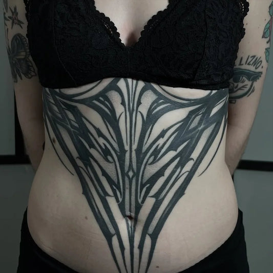 blackwork pattern tattoo on woman stomach