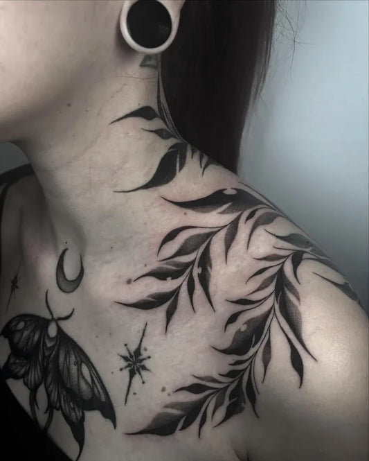 blackwork leaves tattoo on woman shoulder
