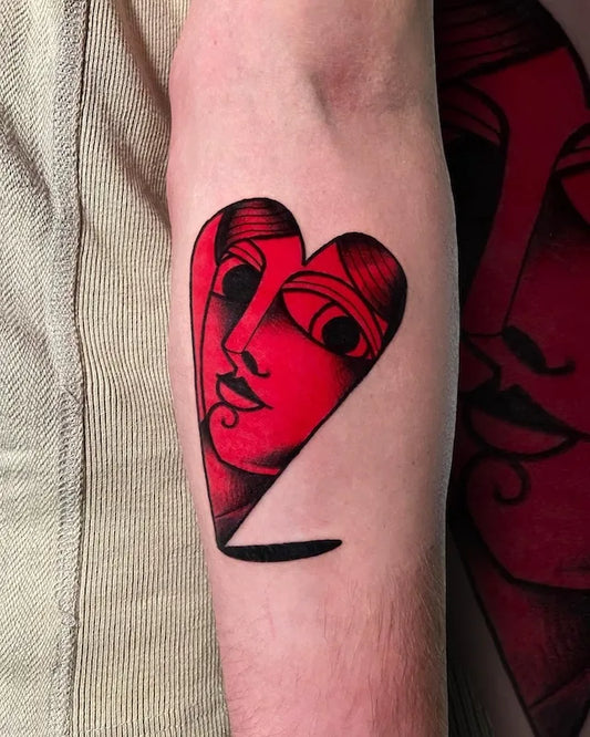 traditional red heart face tattoo on forearm