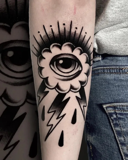 traditional black eye cloud thunderstorm tattoo on forearm