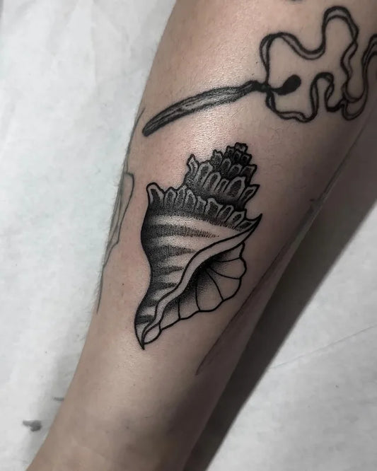traditional black and grey shell tattoo on arm