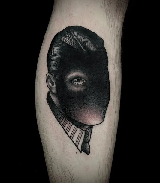 blackwork black face one eye man abstract tattoo on leg