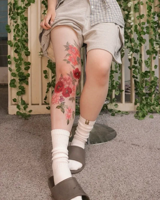 colorful floral tattoo on woman leg sleeve