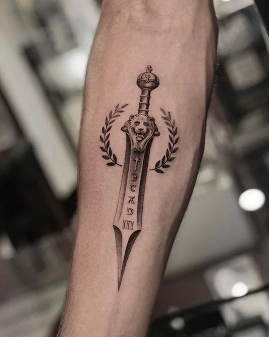 black and grey realism tattoo of a lion sword with laurel leaves on forearm