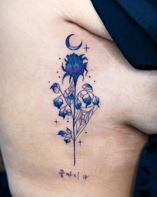 blue flower and moon color realism tattoo on woman rib
