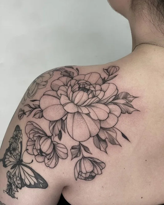 dotwork flower outline and butterfly tattoo on woman shoulder back