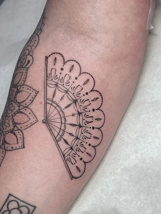 fine line tattoo of a decorative fan outline design