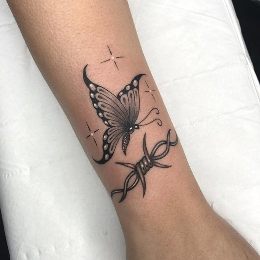 shining butterfly and barbed wire tattoo on woman wrist