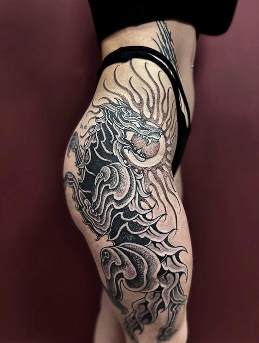 blackwork large piece dragon tattoo on woman thigh leg