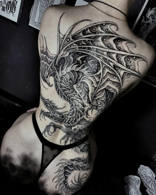 blackwork large piece dargon tattoo on woman back
