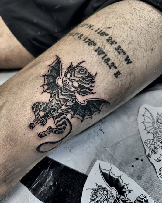 blackwork black and grey winged devil demon tattoo on man thigh