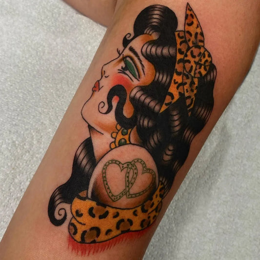 Big American Traditional Pinup Woman with Leopard Print and Heart on Women Arm Tattoo by @plattstatts