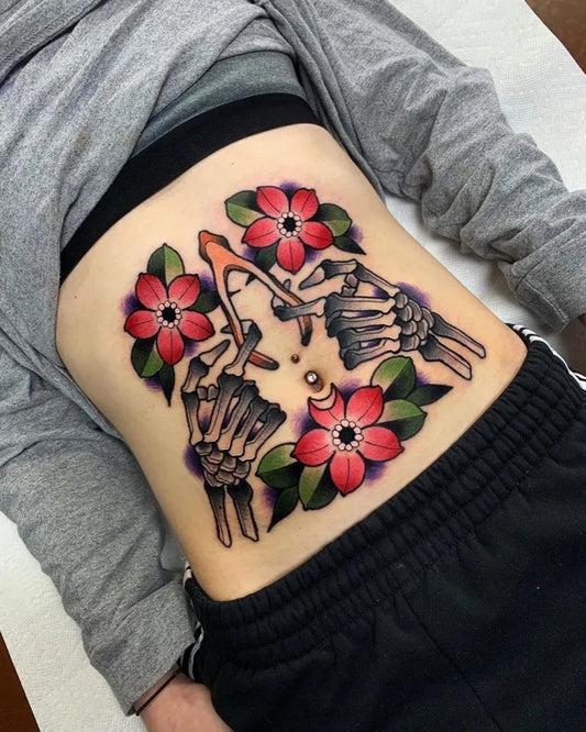 Big American Traditional Skeleton Hands and Flowers Tattoo on Women Stomach by @permanent_legacy