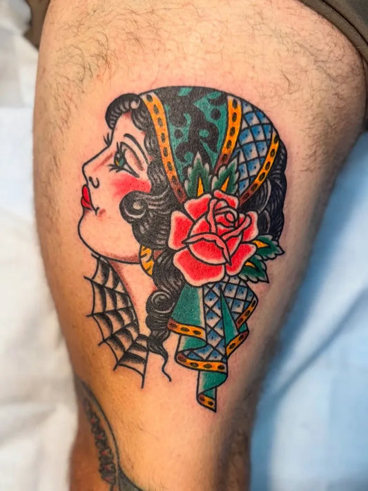 Big American Traditional Woman with Headscarf and Rose on Men Thigh Tattoo by @blaqueowltattoo