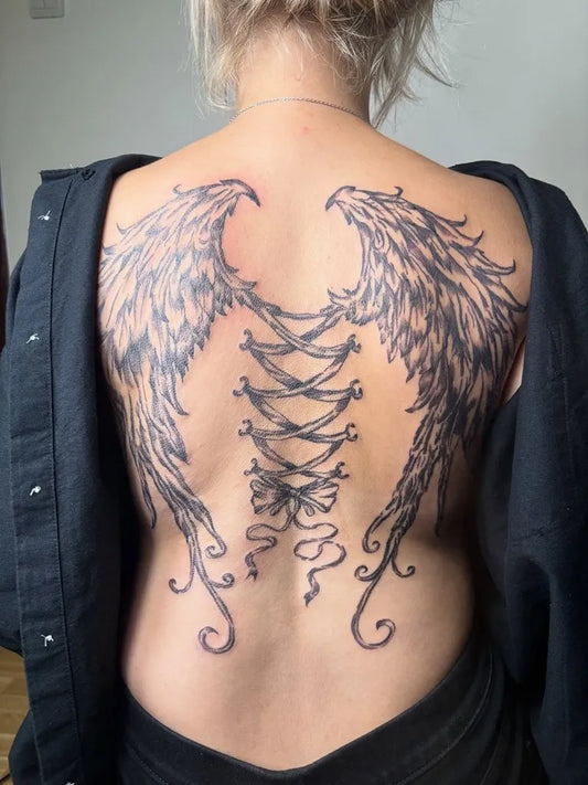 Big Black and Grey Angel Wings with Corset on Women Back Tattoo by @splash.ink.tattoo