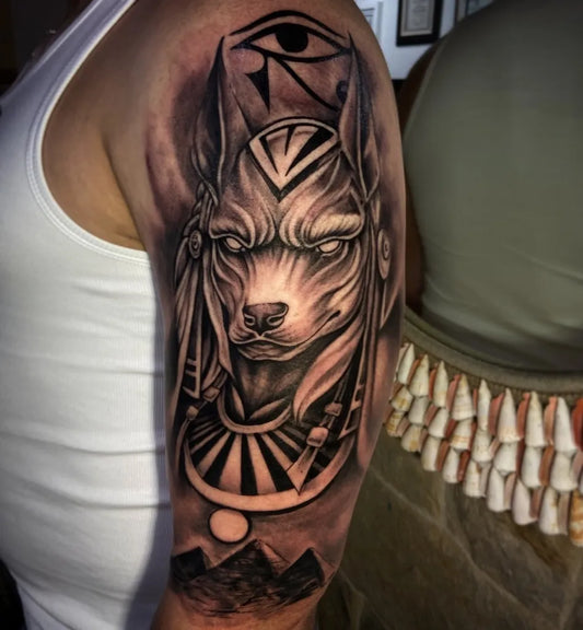 Big Black and Grey Anubis Eye of Horus Tattoo on Men Upper Arm by @la_vicunia