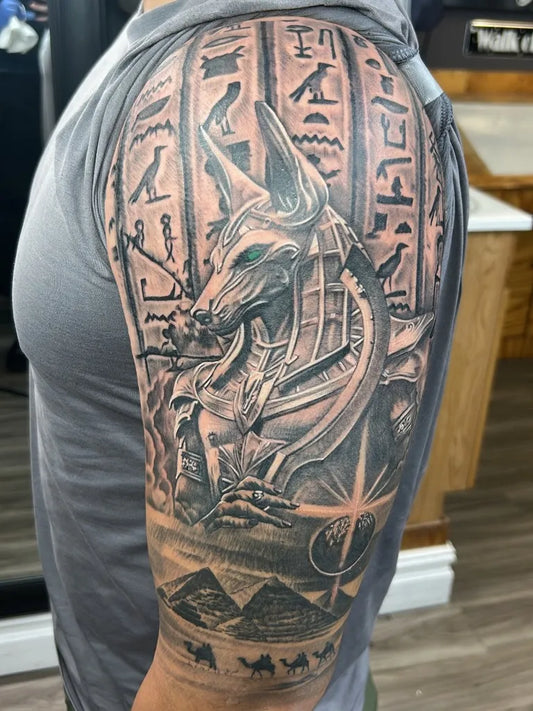 Big Black and Grey Anubis Hieroglyphs Pyramids Tattoo on Men Arm by @tuckansicklifetattoos_official