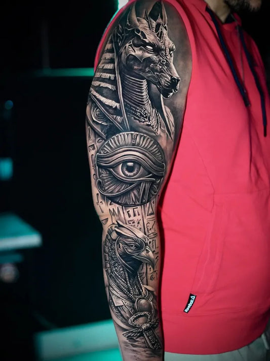 Big Black and Grey Anubis Horus Eye Hieroglyphs Tattoo on Men Arm by @e.h_tattoo