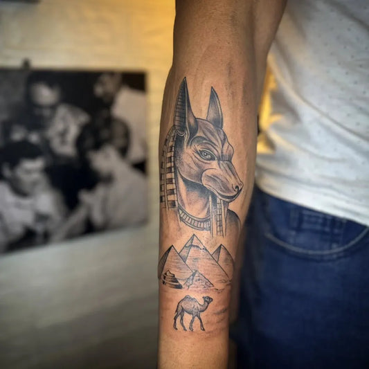 Big Black and Grey Anubis Pyramids Camel Tattoo on Men Arm by @heinrich.tattoos.egypt