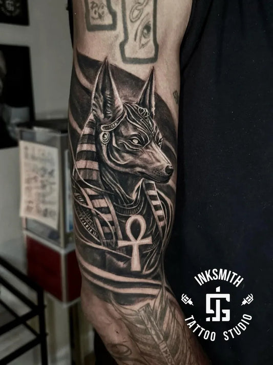 Big Black and Grey Anubis with Ankh Tattoo on Men Arm by @inksmithtattoobda