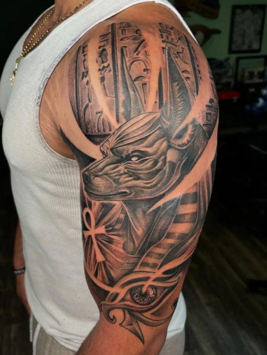 Big Black and Grey Anubis with Ankh and Eye of Horus Tattoo on Men Arm by @enso.inks