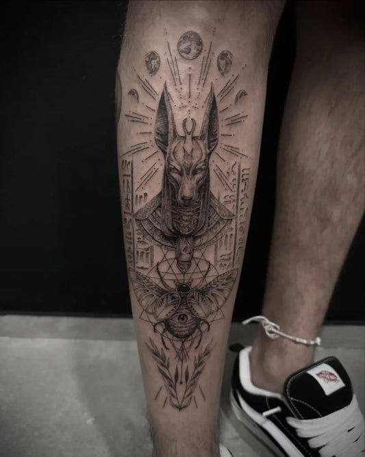 Big Black and Grey Anubis with Egyptian Motifs Tattoo on Men Thigh by @chinox.tattoo