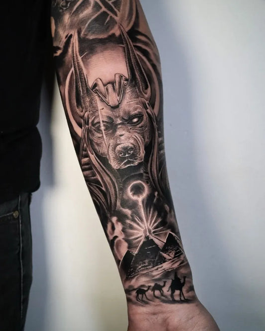 Big Black and Grey Anubis with Pyramids Tattoo on Men Arm by @palermotattoo_oficial