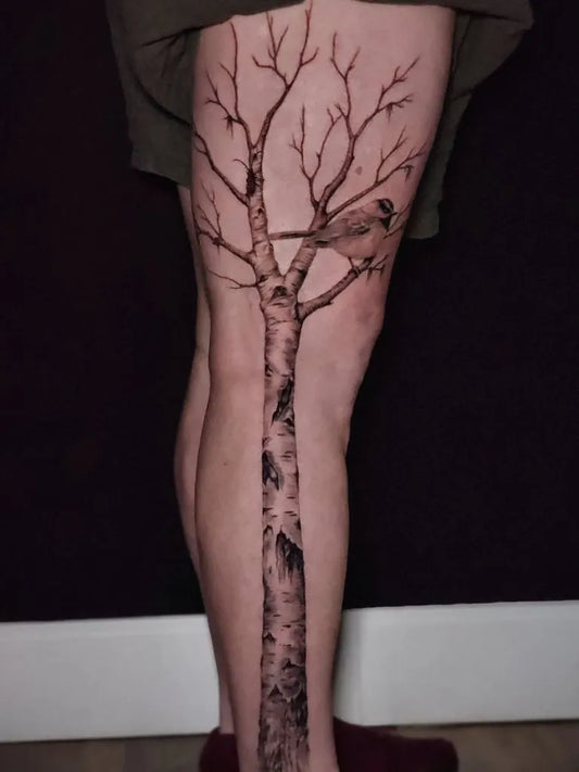 Big Black and Grey Birch Tree with Bird Tattoo on Women Leg by @crystaldawntattoos