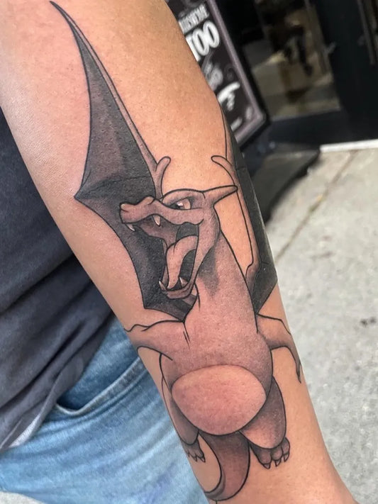 Big Black and Grey Charizard Pokemon Tattoo on Men Arm by @sonjaelise_