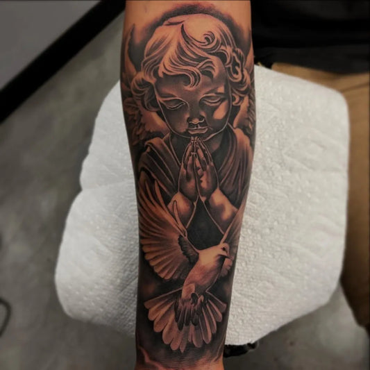 Big Black and Grey Cherub Praying with Dove Tattoo on Men Arm by @jorgevega_tat2s