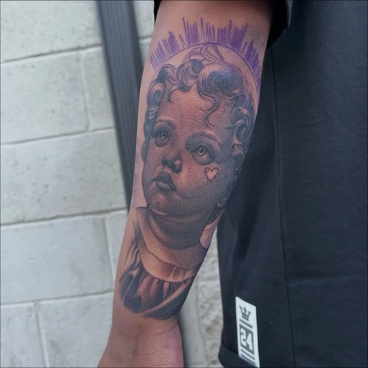 Big Black and Grey Cherub with Halo and Heart Tattoo on Men Arm by @mottatattoos