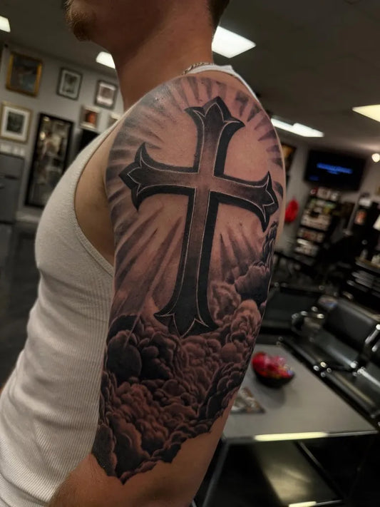 Big Black and Grey Cross with Clouds Tattoo on Men Shoulder by @saltandlighttattoo
