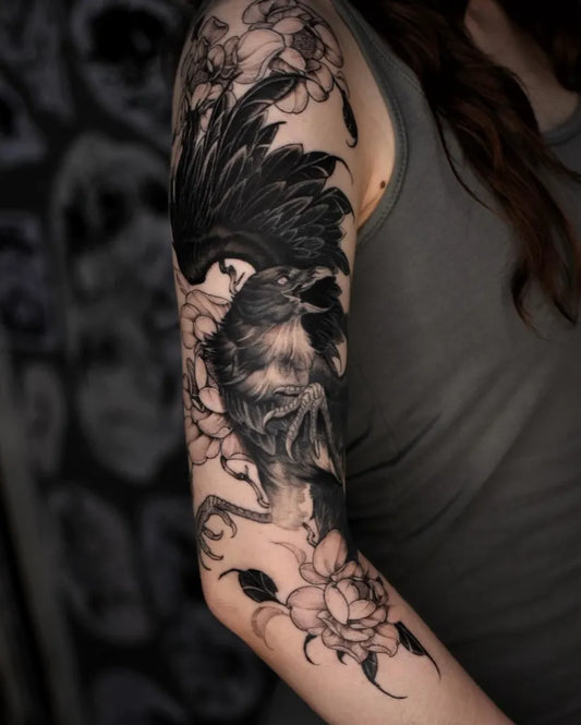 Big Black and Grey Crow with Flowers Tattoo on Women Arm by @penvmbra_tattoo