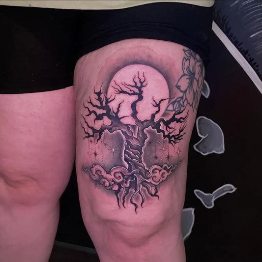Big Black and Grey Dead Tree with Moon and Flowers Tattoo on Women Thigh by @suiteddevilsinkofficial