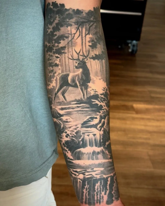 Big Black and Grey Deer Forest Waterfall Tattoo on Men Arm by @adrian_lazaro