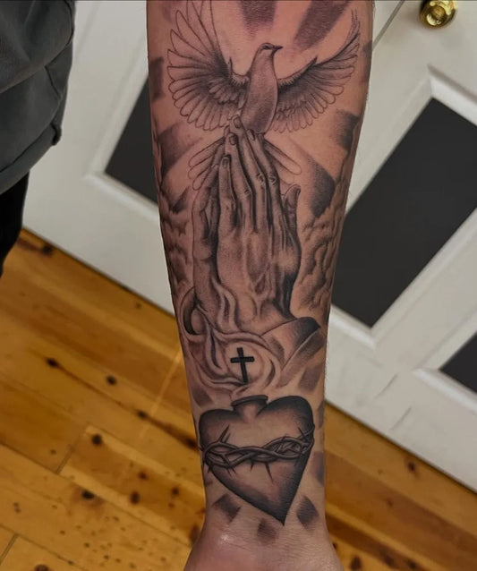 Big Black and Grey Dove Praying Hands Sacred Heart Tattoo on Men Arm by @stephhda.artistt