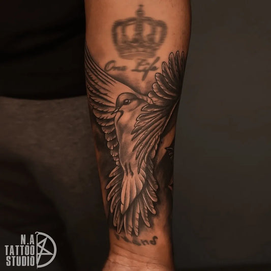 Big Black and Grey Dove with Crown and Wings Tattoo on Men Arm by @natattoostudio