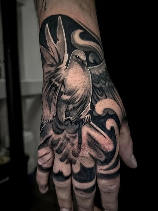Big Black and Grey Dove with Swirls Tattoo on Men Hand by @rezya.tattoo