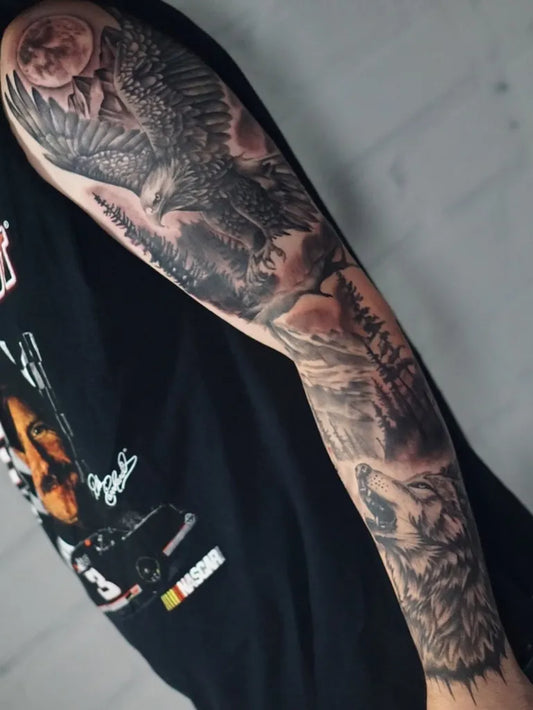 Big Black and Grey Eagle Wolf Forest Tattoo on Men Arm by @tattoos.by.cr