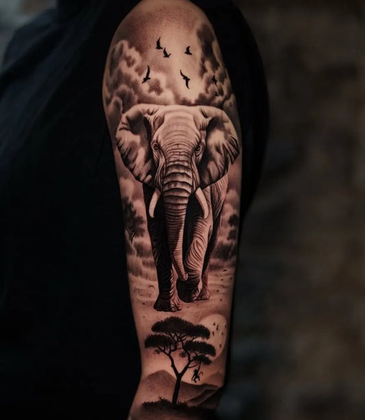 Big Black and Grey Elephant with Clouds and Tree Half Sleeve Tattoo on Men Arm by @olyangertattoo