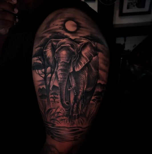 Big Black and Grey Elephant with Savanna Moon Tattoo on Men Arm by @coverup_kev