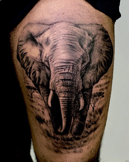 Big Black and Grey Elephant with Tusks and Savanna Tattoo on Men Thigh by @peter_tattooist