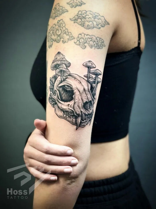 Big Black and Grey Fox Skull with Mushrooms Tattoo on Women Upper Arm by @hoss.tattoo