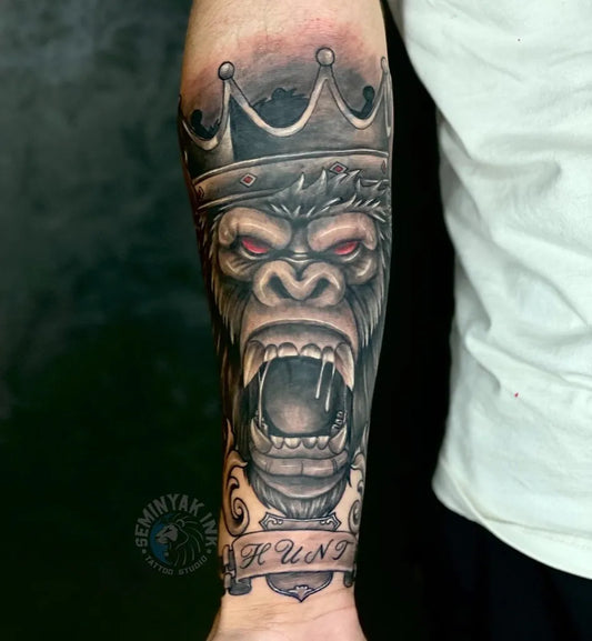 Big Black and Grey Gorilla Crown Banner Tattoo on Men Arm by @seminyakinkbali
